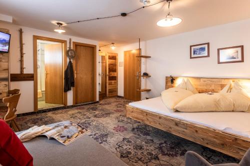 a bedroom with a large bed with a wooden frame at Pension Seighof in Saalbach Hinterglemm