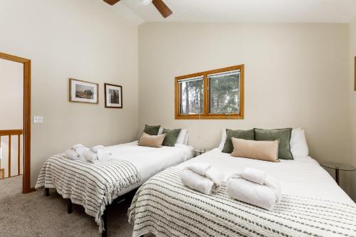 two beds in a room with white walls at Up North Chalet Ac Bbq Bikes in Cedar