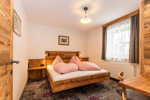 a bedroom with a bed with pink pillows at Pension Seighof in Saalbach Hinterglemm