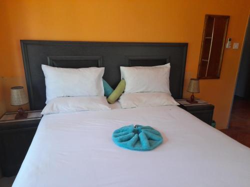 a large white bed with a blue bow on it at African Sunsets (Bophirimo Self-Catering Guest House) in Kasane