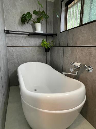 a bathroom with a white tub and a sink at 海近!サウナとBBQが楽しめる一棟貸しOURHOUSE-Mie in Nishiki