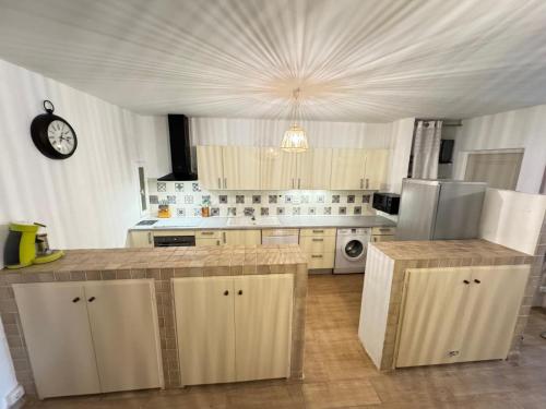 a kitchen with white cabinets and a clock on the ceiling at Fiori di sperenza in Coggia