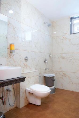 a bathroom with a white toilet and a sink at Hotel Heera Residency in Bhopal