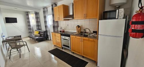 Una cocina con gabinetes de madera y un refrigerador blanco. en Sunset Star II With Sea View, en Calheta