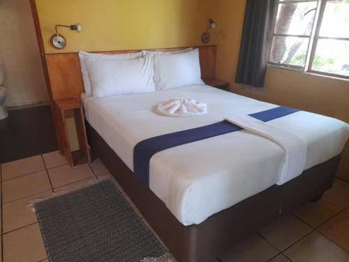 a bed with a towel on top of it at African Sunsets (Bophirimo Self-Catering Guest House) in Kasane