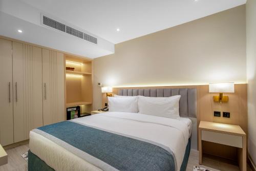 a bedroom with a large bed with white pillows at Grand Ambassador Hotel in Dubai