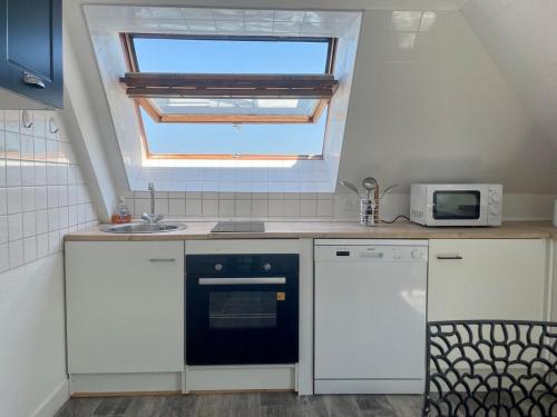 - une cuisine avec une fenêtre, un évier et une cuisinière dans l'établissement Bellavista #9 by Melrose, à Arromanches-les-Bains