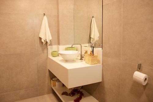 a bathroom with a sink and a mirror at Casa da árvore com 5 suítes in Cabo de Santo Agostinho