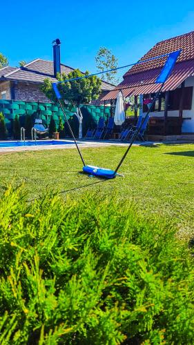 two swings in the grass in front of a house at Vikendica Drinski LAD in Loznica