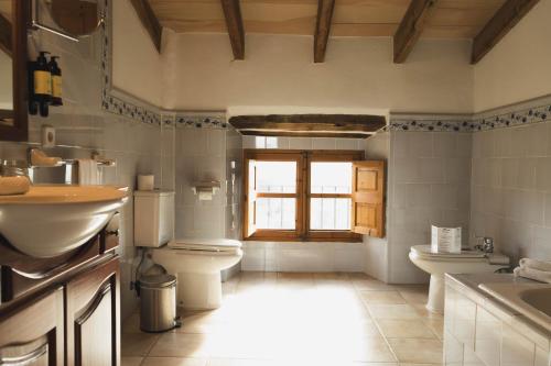 a bathroom with a sink and a toilet and a window at Finca Can Estades in Calvia Town