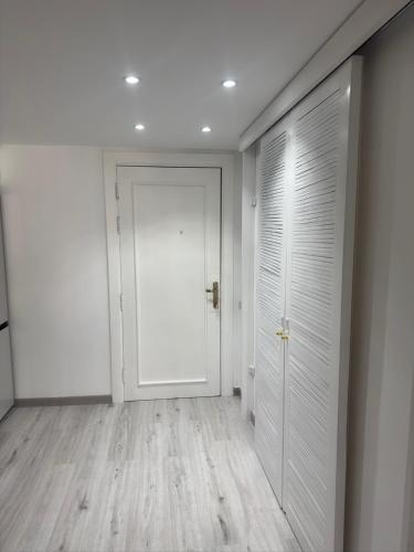 an empty hallway with a white door and wooden floors at Suite Elisir Egitto Domina Coral Bay Resort in Sharm El Sheikh
