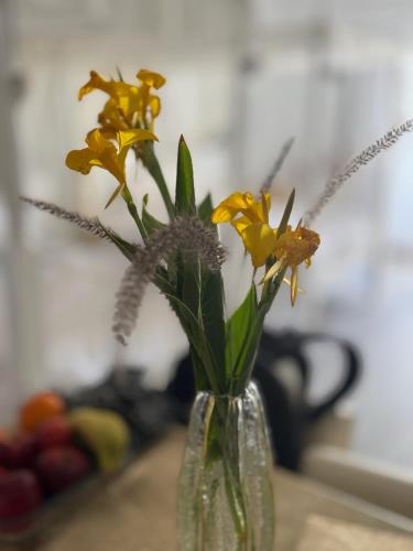 a glass vase filled with yellow flowers on a table at Suite Elisir Egitto Domina Coral Bay Resort in Sharm El Sheikh