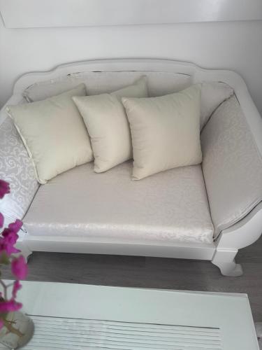 a white couch with three white pillows on it at Suite Elisir Egitto Domina Coral Bay Resort in Sharm El Sheikh