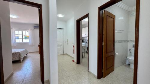 a hallway with a bathroom with a toilet and a door at Altura Beach Apartment in Altura