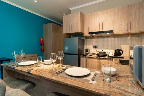 a kitchen with a counter with plates and wine glasses at Thalassa Seychelles in Beau Vallon