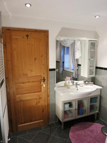 La salle de bains est pourvue d'un lavabo, d'un miroir et d'une porte. dans l'établissement Villa Roma, à Losheim