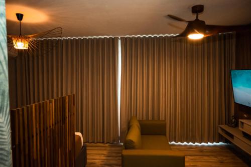 a living room with a couch and a television at Seaside Escape at Luquillo Beach - Palma Luxe Studio in Luquillo
