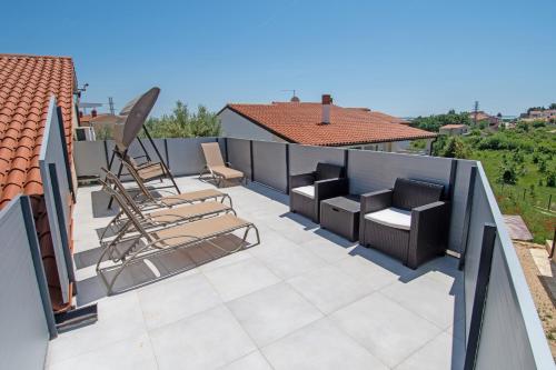 een dakterras met stoelen en een patio bij Villa Canolle Istria in Vodnjan