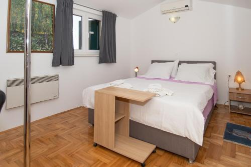 a bedroom with a bed and a wooden table at Villa Valencan 1 in Vodnjan