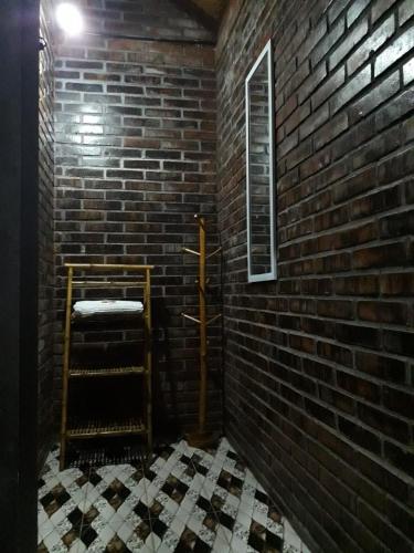 a room with a brick wall and a stair case at Chez B&S Linares in Celep