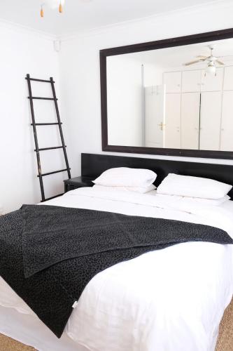 a bedroom with a large mirror above a bed at Villa on Flamingo Vlei in Cape Town