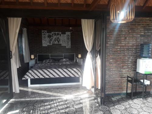 a bedroom with a bed in a brick wall at omah linares in Celep