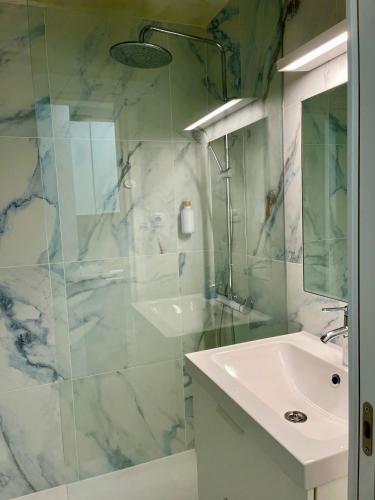 a bathroom with a sink and a glass shower at Las Torres del Castillo, 208Marina in Costa de Antigua