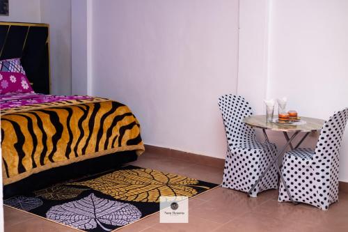 a room with a bed and a table and chairs at Nem Resorts La Résidence in Bayangam