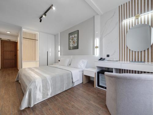 a bedroom with a bed and a desk and a mirror at Hotel Tara Becici in Budva