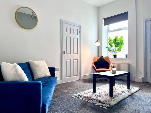 a living room with a blue couch and a table at Devon-2 Bdrm Sleeps 4 Great for Contractors in Monkwearmouth