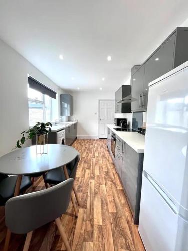 a large kitchen with a table and a refrigerator at Devon-2 Bdrm Sleeps 4 Great for Contractors in Monkwearmouth