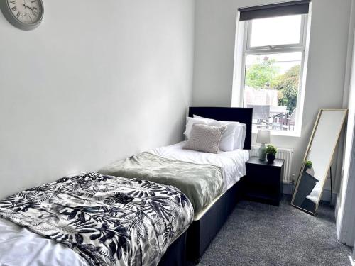 a bedroom with a bed and a mirror and a window at Devon-2 Bdrm Sleeps 4 Great for Contractors in Monkwearmouth