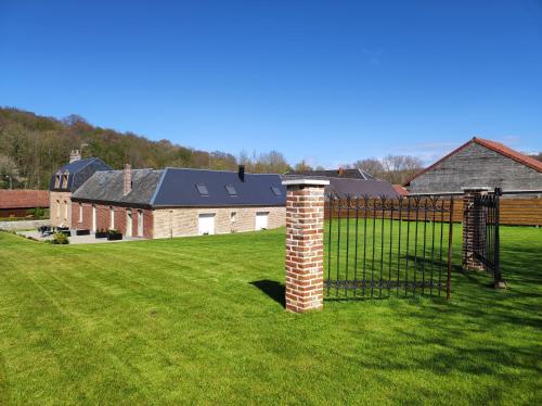 une clôture dans un champ avec une maison dans l'établissement Le clos des Prêles, à Boismont