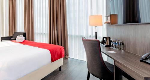 a hotel room with a bed and a desk at PLAZA Premium Almere in Almere