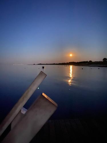 a boat in the water with the sunset in the background at Camp Hverringe in Dalby