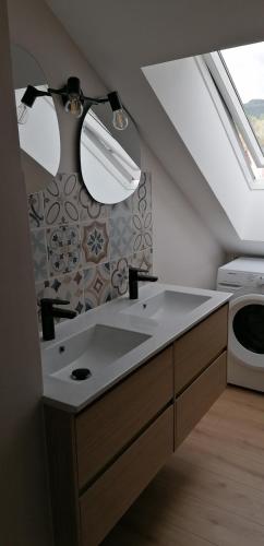 une salle de bain avec un lavabo et une machine à laver dans l'établissement Appartement neuf dans Résidence, à La Bourboule