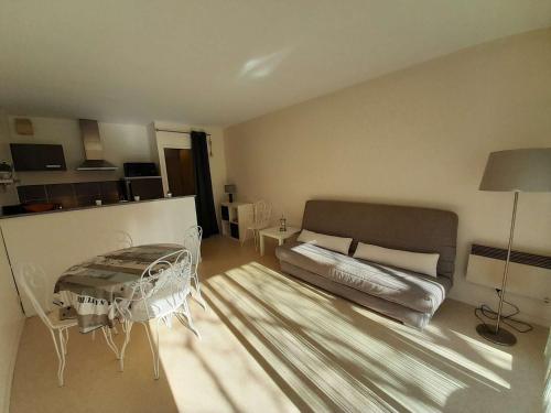 - un salon avec un lit et une table dans l'établissement Charmant T2 rénové à 600m de la plage et 300m du port avec terrasse et stationnement - FR-1-324-235, à Saint-Gilles-Croix-de-Vie