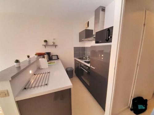 une petite cuisine avec un comptoir et un réfrigérateur dans l'établissement Charmant T2 rénové à 600m de la plage et 300m du port avec terrasse et stationnement - FR-1-324-235, à Saint-Gilles-Croix-de-Vie