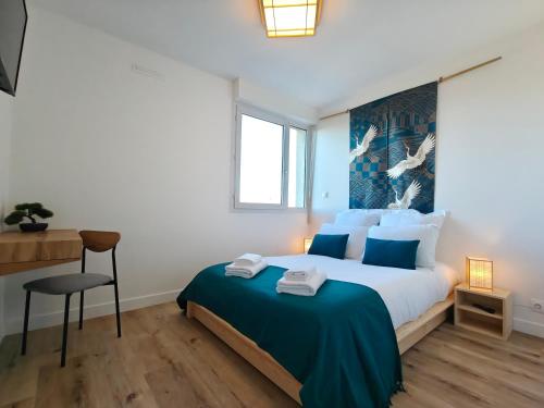 une chambre avec un grand lit avec une couverture bleue dans l'établissement La Parenthèse Zen - Grande terrasse avec vue, à Toulouse