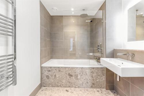 a bathroom with a tub and a sink at Synergy Bloom Nine Elms in London