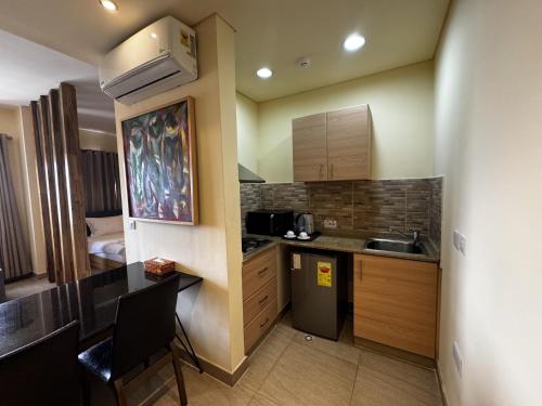 a small kitchen with a sink and a counter at Roots Hotel Apartment in Accra