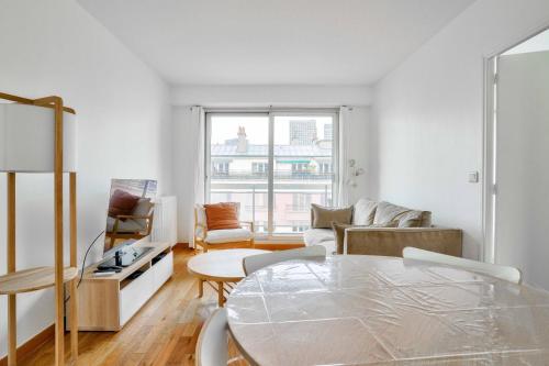 un salon avec une table et un canapé dans l'établissement GuestReady - Charming stay with a view, à Paris