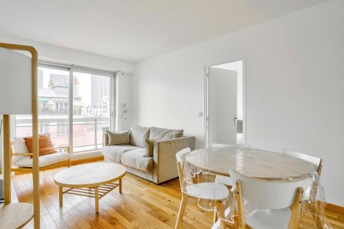 un salon avec une table en verre et un canapé dans l'établissement GuestReady - Charming stay with a view, à Paris