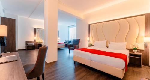 a hotel room with a large bed and a desk at PLAZA Premium Almere in Almere