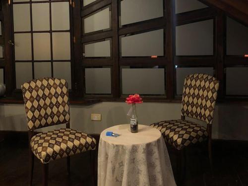 two chairs and a table with a vase of flowers at La Posada Encantada in Mar del Plata