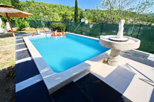 a swimming pool with a fountain in a yard at Holiday Home Marco's Place in Vela Luka