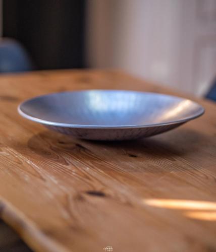 un bol en métal assis au-dessus d'une table en bois dans l'établissement Résidence St Vincent, à Collioure