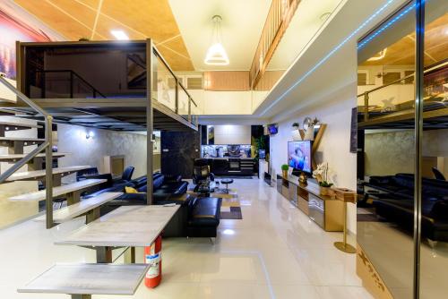 sala de estar con escalera, sofá y mesas en XSpa Apartment cryptocurrency pay available, en Novi Sad