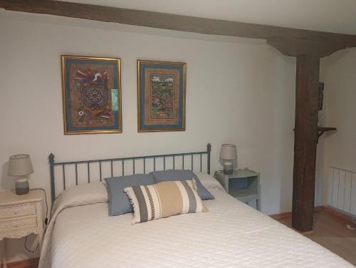 a bedroom with a bed with two pictures on the wall at Las Gallinas de María in San Miguel de Aras