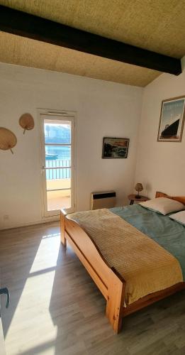 une chambre avec un grand lit et une fenêtre dans l'établissement Maison de vacances unique, au bord de la mer, proche plages, à Saint Cyprien Plage